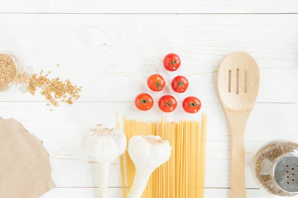 Tomatoes and raw pasta — Stock Photo