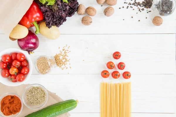 Tomatoes and raw pasta — Stock Photo