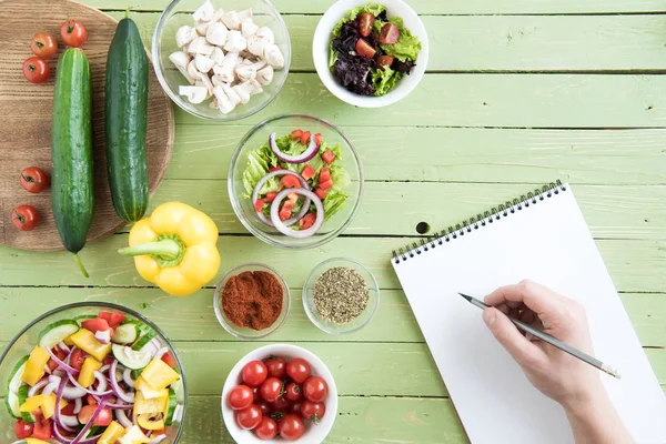 Persona che cucina con ricettario — Foto stock