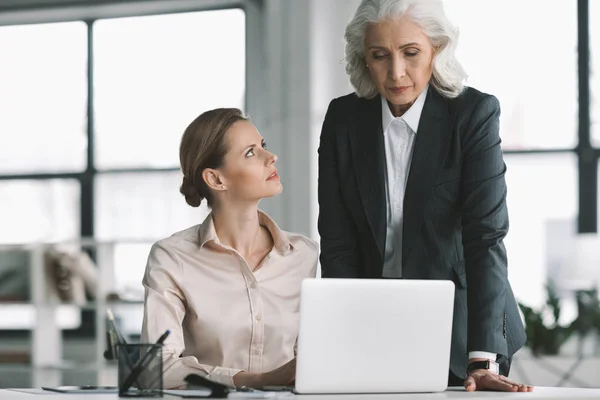 Businesswoman and her boss working with laptop — Stock Photo