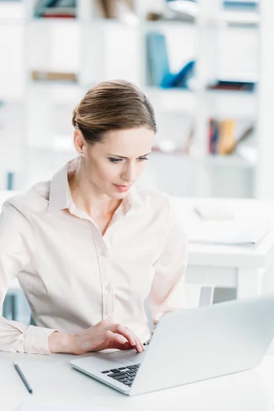 Businesswoman working on laptop at office — Stock Photo