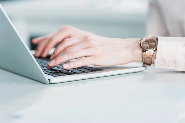 Donna d'affari con orologi a mano che lavora sul computer portatile — Foto stock