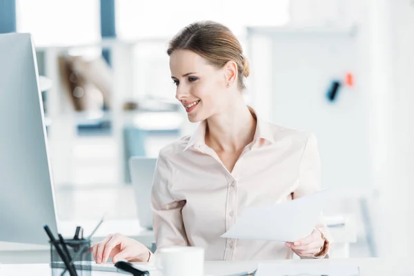 Geschäftsfrau arbeitet im Büro mit Dokumenten und Computer — Stockfoto
