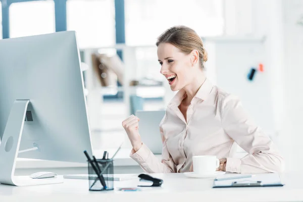 Heureuse femme d'affaires assise au bureau — Photo de stock