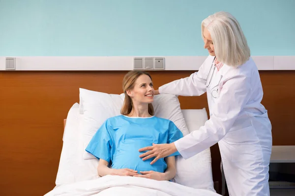 Médico y mujer embarazada - foto de stock