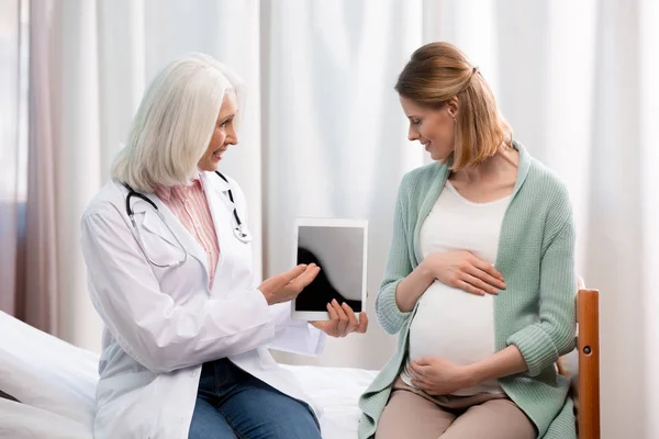 Médico y mujer embarazada - foto de stock