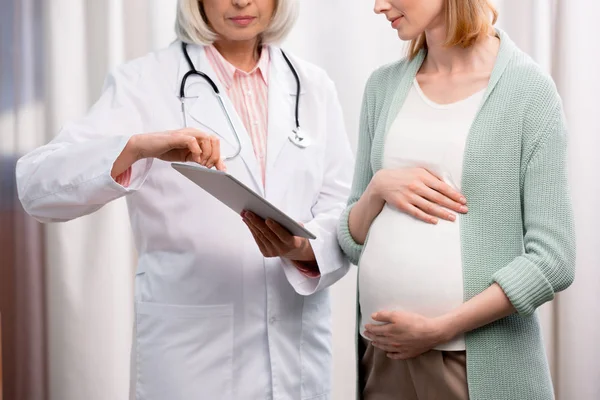 Doctor showing results of examination to woman — Stock Photo