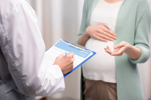 Arzt mit Schwangerer während der Konsultation — Stockfoto