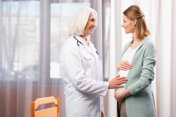 Médico y mujer embarazada - foto de stock