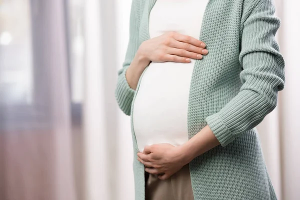 Pregnant woman holding stomach — Stock Photo