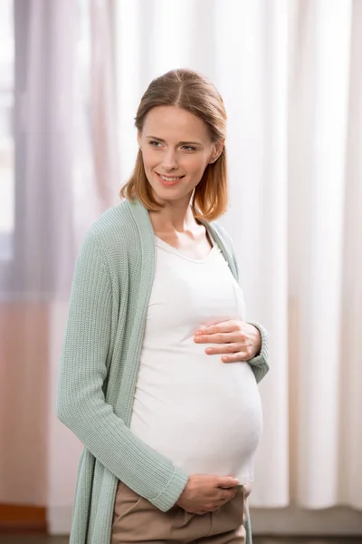 Joven mujer embarazada sonriente - foto de stock