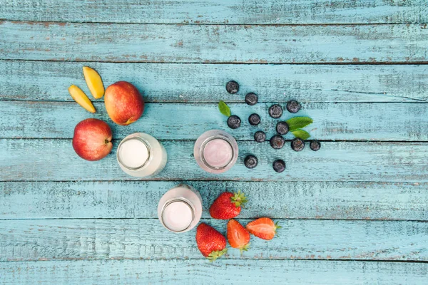 Milkshakes en bouteilles en verre avec des baies et des fruits — Photo de stock