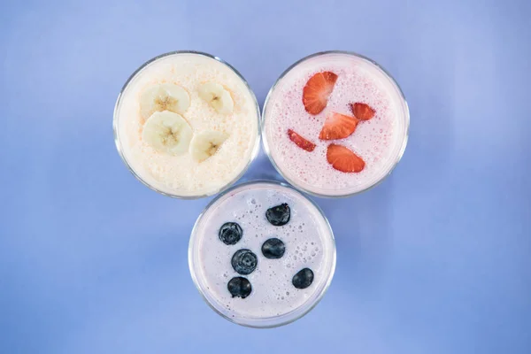 Банановые и ягодные молочные коктейли в стаканах — стоковое фото