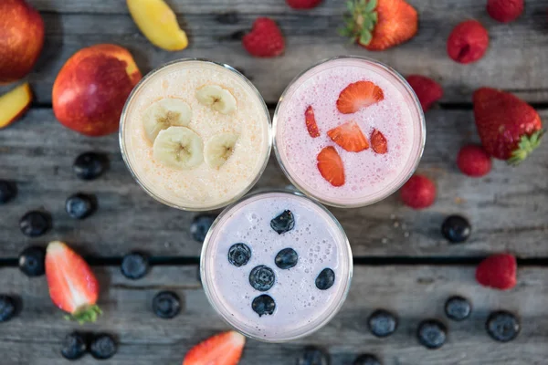 Milkshakes à la banane et aux baies dans des verres — Photo de stock