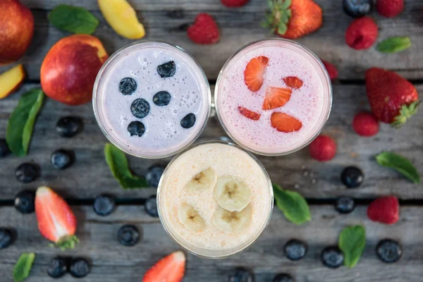 Milkshakes à la banane et aux baies dans des verres — Photo de stock