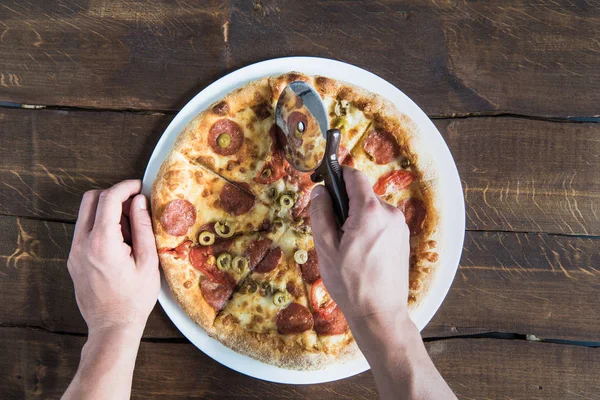Pessoa que corta pizza — Fotografia de Stock