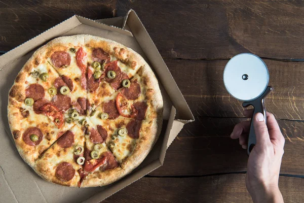 Person cutting pizza — Stock Photo