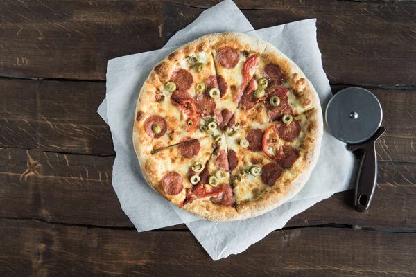 Italian pizza and pizza cutter — Stock Photo