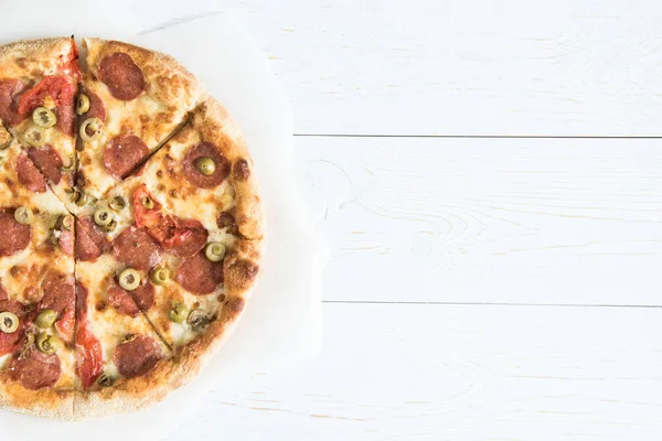 Italian pizza on baking paper — Stock Photo