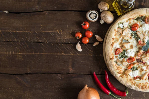 Pizza italienne avec des ingrédients sur la table — Photo de stock