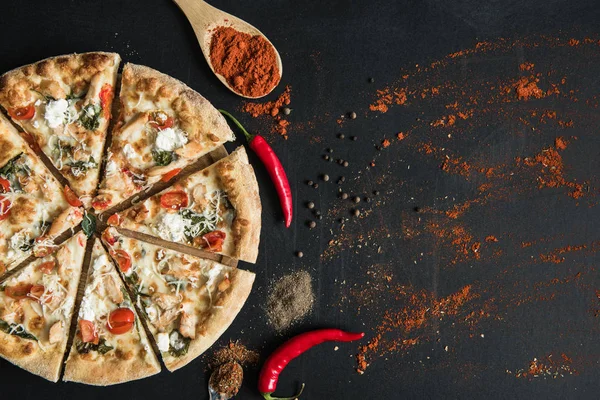 Italienische Pizza in Scheiben geschnitten mit Gewürzen und Kräutern — Stockfoto