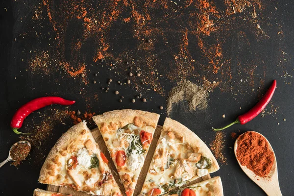 Sliced italian pizza with spices and herbs — Stock Photo