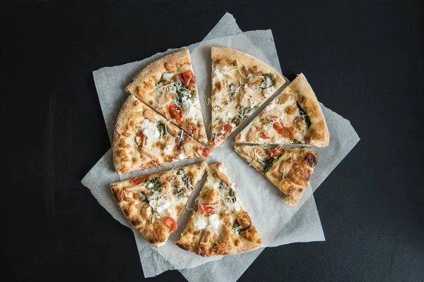 Pizza italienne traditionnelle tranchée sur parchemin — Photo de stock