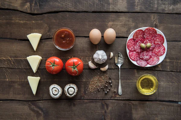 Ingredients for preparing pizza on wooden tabletop — Stock Photo