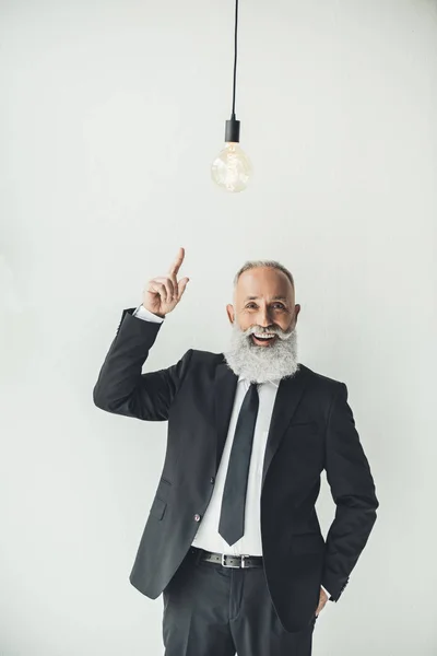 Geschäftsmann zeigt auf Glühbirne — Stockfoto