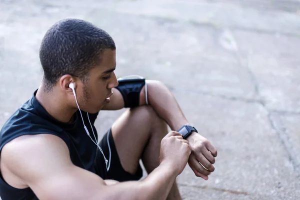Esportista afro-americano usando smartwatch — Fotografia de Stock
