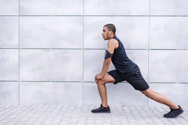 Afroamericano corredor estiramiento en calle - foto de stock