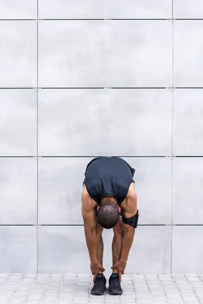 Coureur afro-américain s'étirant sur la rue — Photo de stock