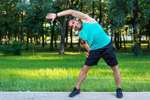 African american sportsman stretching in park — Stock Photo