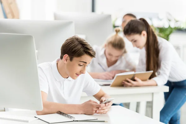 Adolescente usando smartphone em sala de aula — Fotografia de Stock