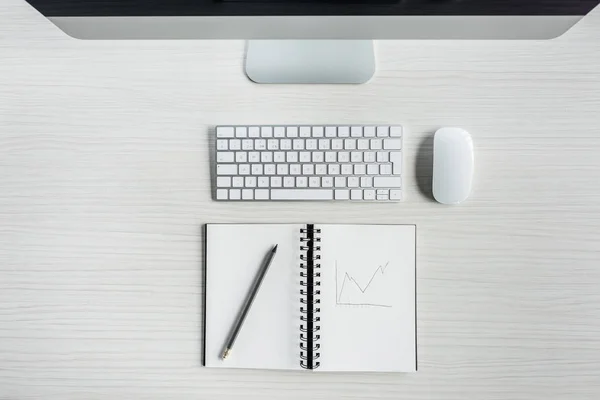 Digital devices and notebook on table — Stock Photo