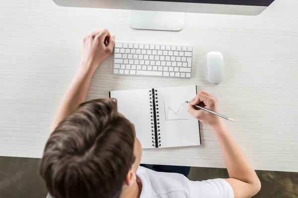 Estudiante dibujo gráfico mientras hace la tarea - foto de stock