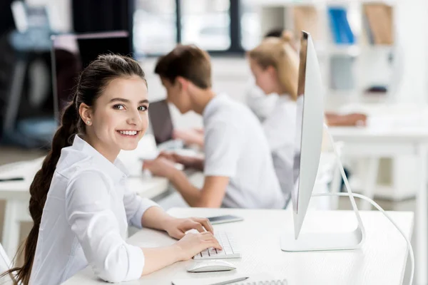 Chica adolescente escribiendo en el teclado de la computadora - foto de stock