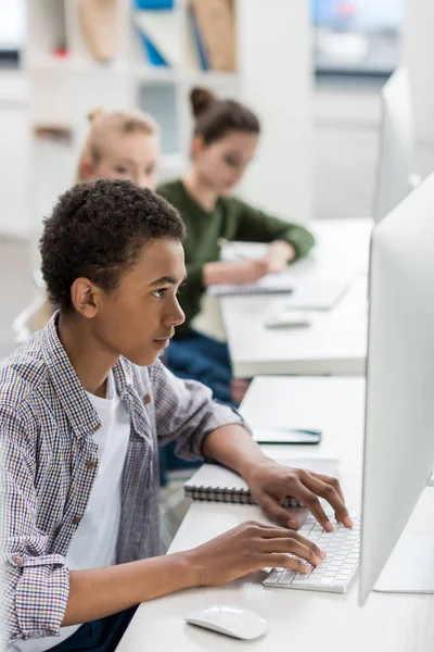 Afroamericano adolescente trabajando en computadora - foto de stock