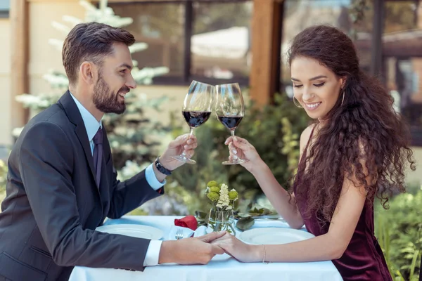 Couple clinking glasses on date — Stock Photo