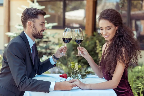 Paar klirrt bei Date mit Gläsern — Stockfoto