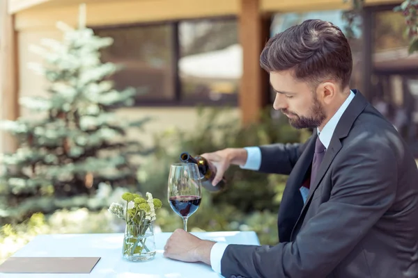 Mann schenkt Wein ein — Stockfoto