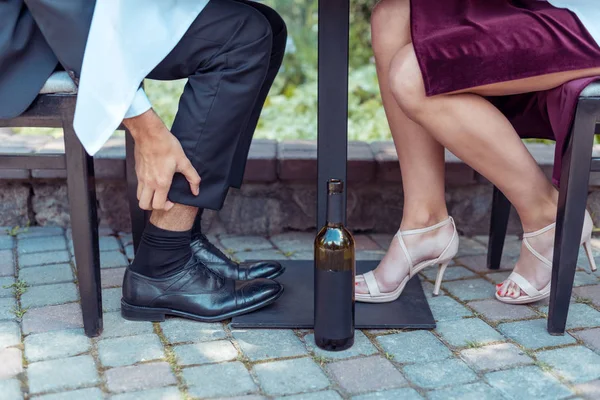 Homme se gratter la jambe à la table — Photo de stock