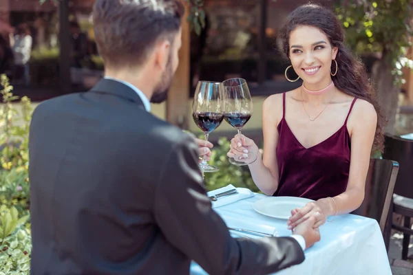Paar klirrt bei Date mit Gläsern — Stockfoto