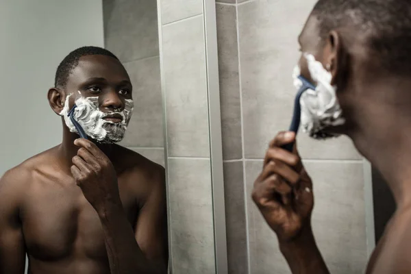 Homme afro-américain réfléchi rasage — Photo de stock