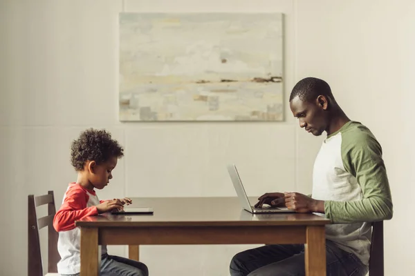 Père et fils utilisant ordinateur portable et tablette — Photo de stock