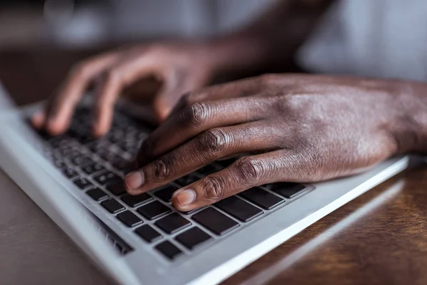 Afro hombre escribiendo en el ordenador portátil - foto de stock