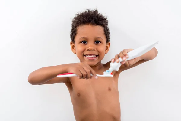 Bambino che applica la pasta dentaria sul pennello — Foto stock