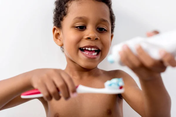 Kid applying tooth paste on brush — Stock Photo