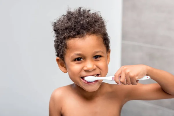 Afro kid brushing teeth — Stock Photo