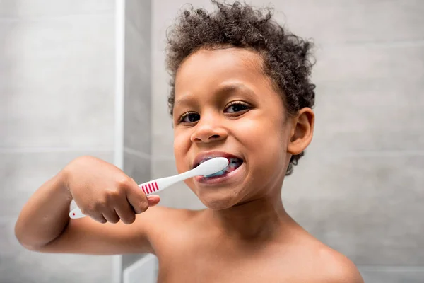 Afro kid brushing teeth — Stock Photo